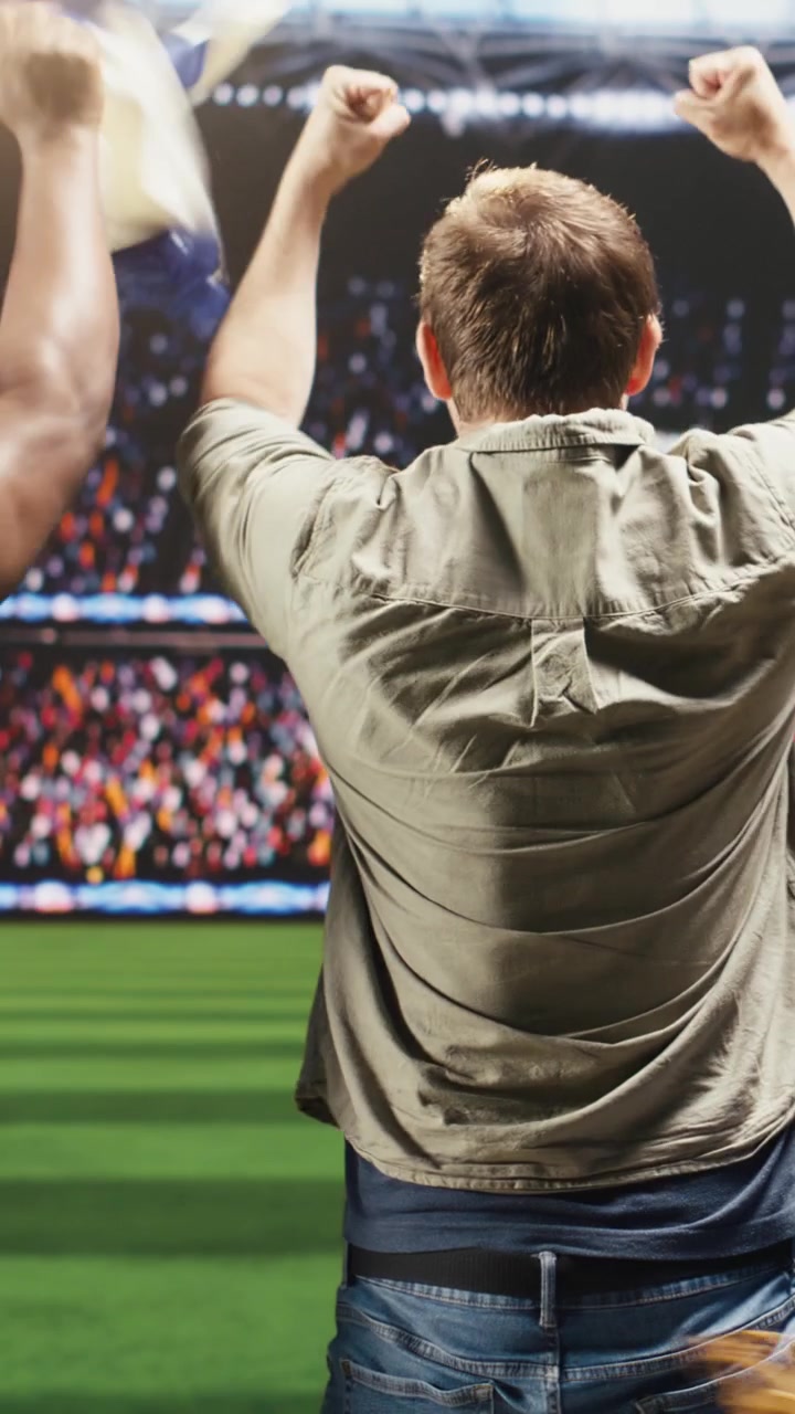 Video verticale. Tifosi di calcio festeggiano un gol a casa, guardando la partita su una trasmissione TV interattiva.