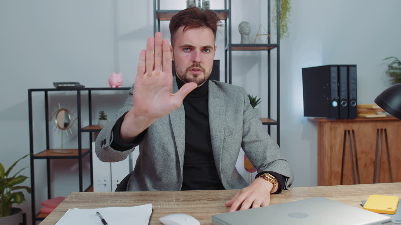 hombre de negocios trabajando en una computadora portátil que muestra gesto de parada, peligro, rechazo, advertencia, crisis, prohibición