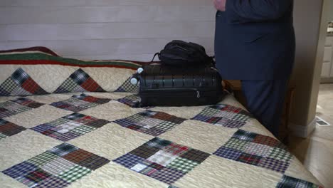older executive man in a suit takes his luggage and leaves on a business trip