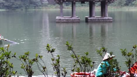 gente remando en un bote cerca del pabellón en el río