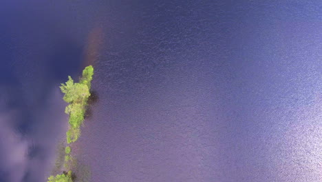 drone bank turn video of a stunning small island in a finnish forest lake