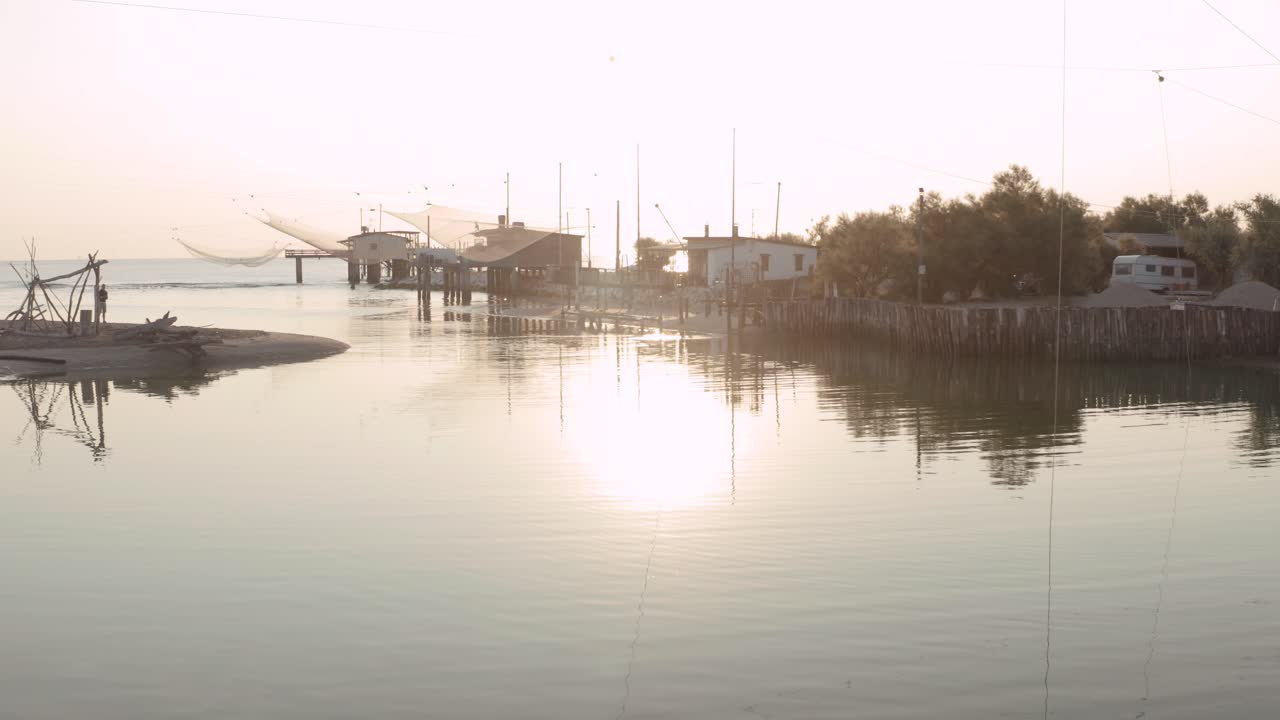 comacchio 계곡 근처의 fiumi uniti ravenna, lido di dante, fiumi uniti ravenna, "trabucco"라고 불리는 전형적인 이탈리아 낚시 기계가 있는 해가 뜰 때 강에 있는 낚시 오두막의 풍경