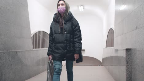 woman wearing mask walking in an underground tunnel