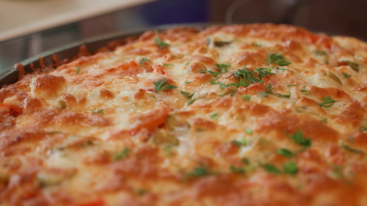 Vista dal basso di una pizza al formaggio appena sfornata con condimento fuso che bolle, macchie dorate e abbrustolite, superficie lucida, erbe verdi tritate, crosta croccante e un aspetto caldo e artigianale per uso alimentare.