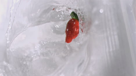 strawberry falling into water in super slow motion