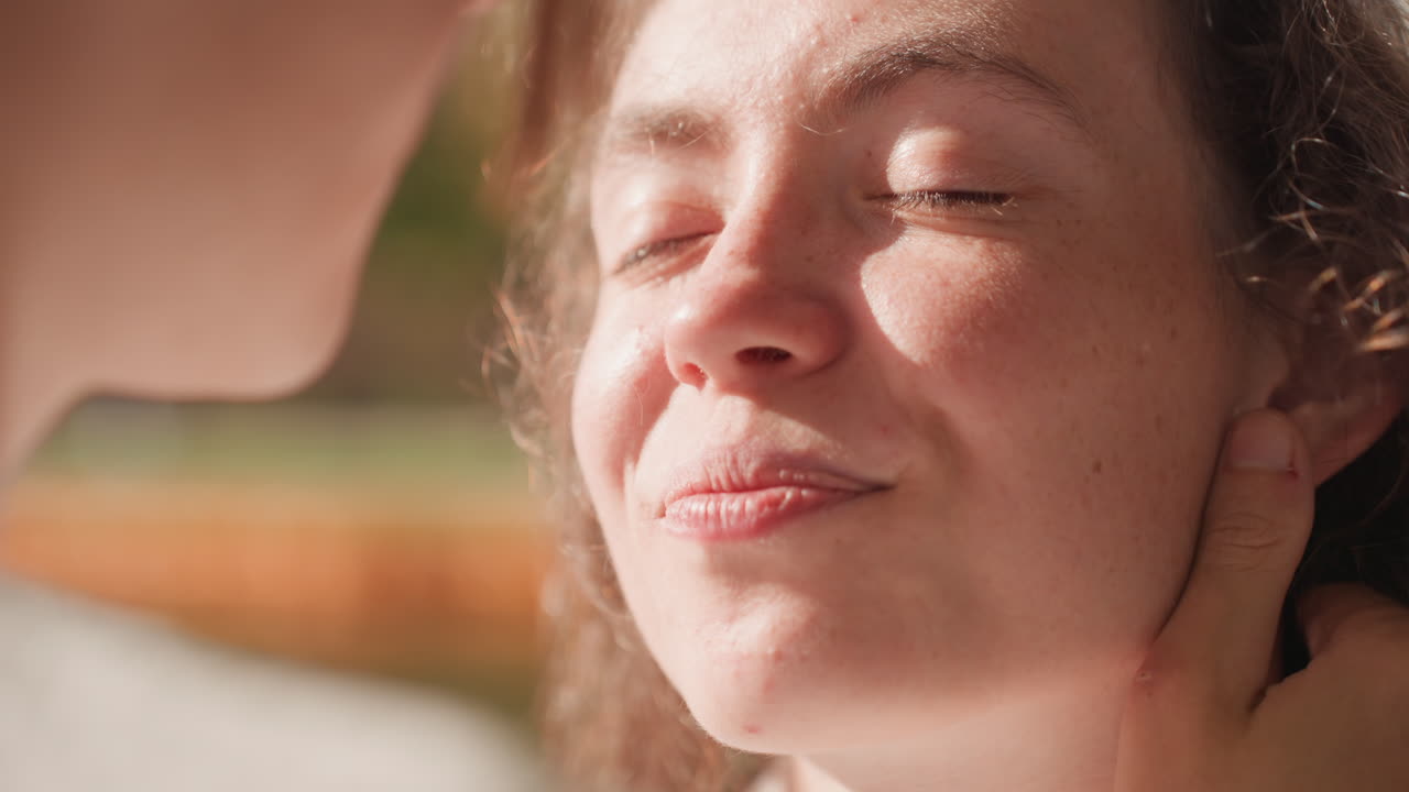 Caucasian woman content closeup by lake sunlight, partners planning future family exchange quiet commitment, hand at nape, peaceful smile conveying trust and lasting marriage bond