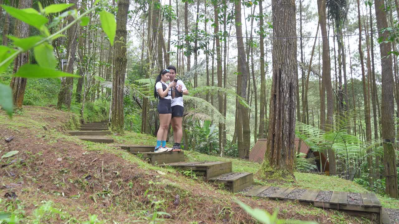Indonesian young adults using smartphone during trail run in forest