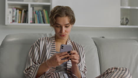 woman enjoy online communication in morning. smiling girl use smartphone closeup