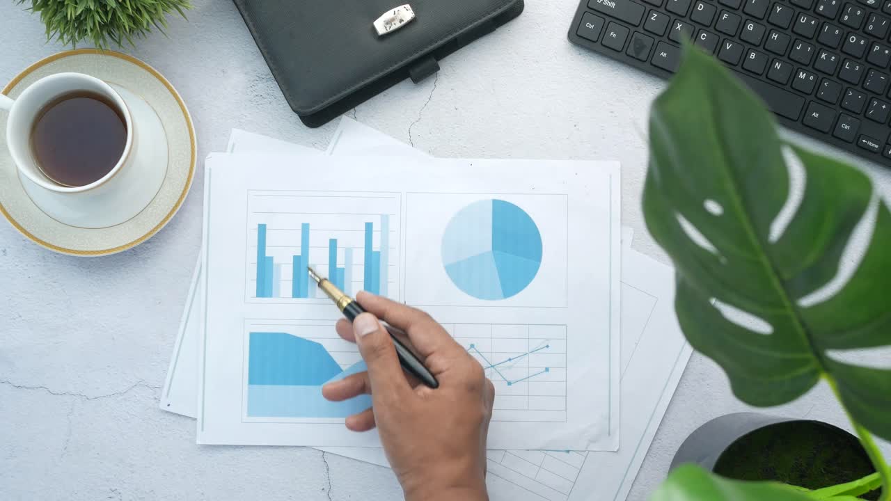 Person gennemgår virksomhedsdiagrammer ved skrivebord