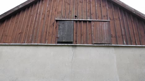 traditional village house with wooden roof and concrete walls in pradzonka, poland - tilt-down shot