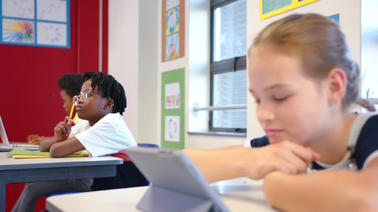 In school, girl using tablet in classroom, focusing on digital learning