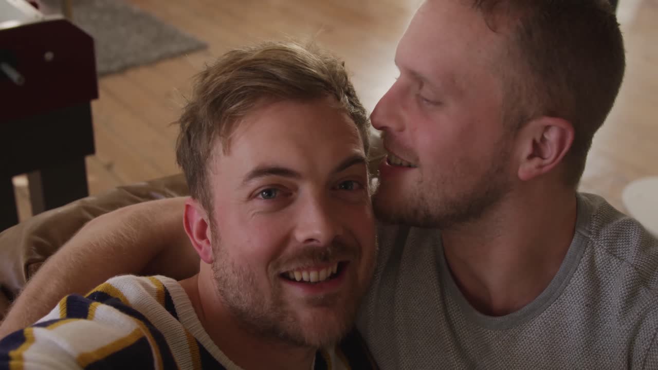 Caucasian male couple in social distancing in their sofa at home