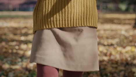 Tilt-down-of-caucasian-girl-walking-across-the-park-with-colorful-umbrella.