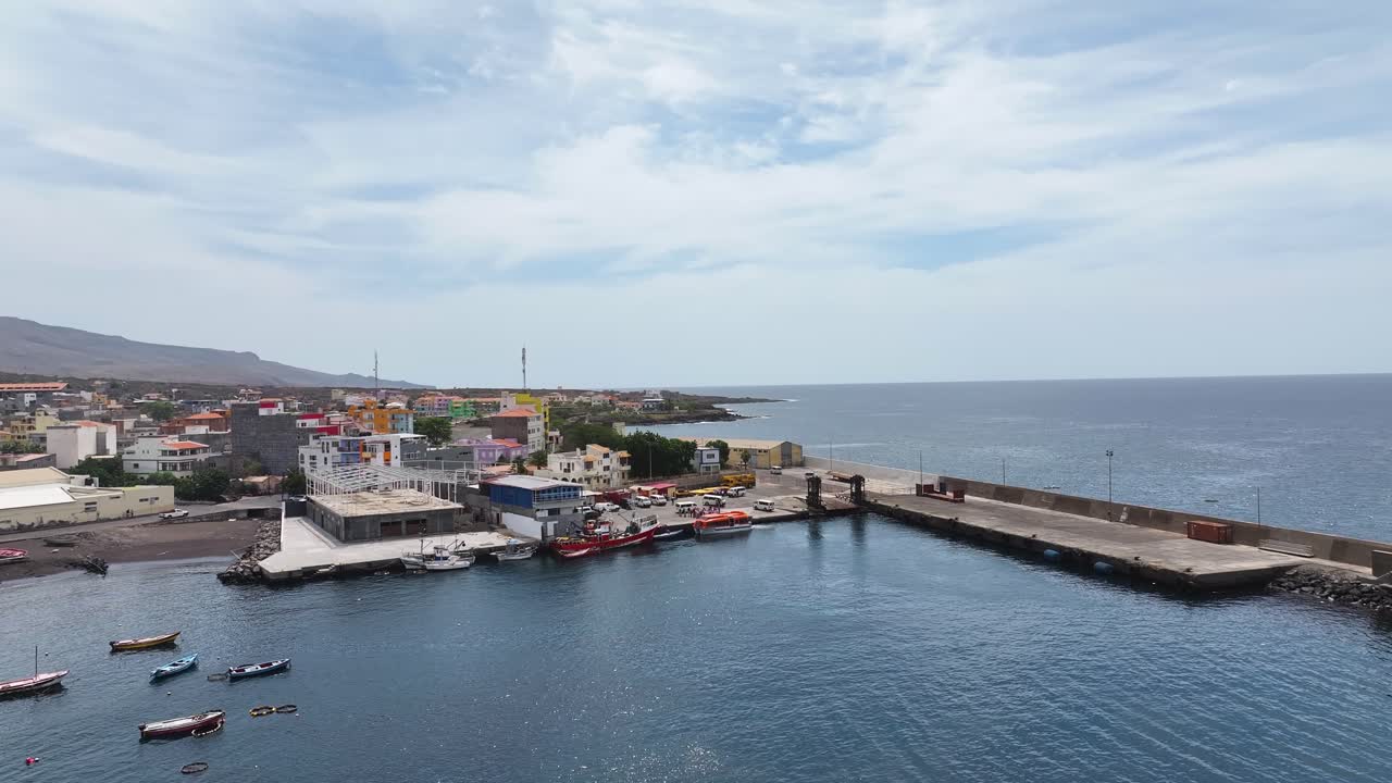 Aerial view of a coastal town with a harbor and colorful buildings