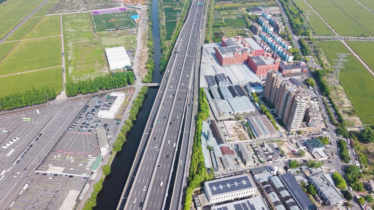 Pemandangan drone udara jalan raya dan kawasan industri di Hangzhou Xiaoshan, Tiongkok, dengan pembangunan perkotaan, infrastruktur logistik, dan lahan pertanian di sekitarnya di bawah cahaya siang yang cerah. UHD.