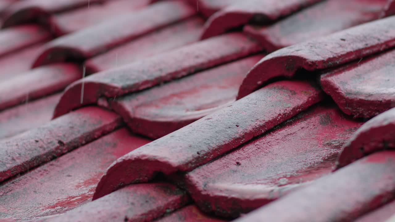 Gentle rain pattering on a weathered red tile roof