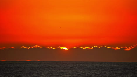 massive red sunrise over ocean horizon, time lapse view