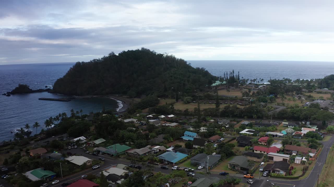 Low aerial shot flying over the small Hawaiian town of Hana towards the extinct crater Ka'uiki Head on the island of Maui in Hawai'i