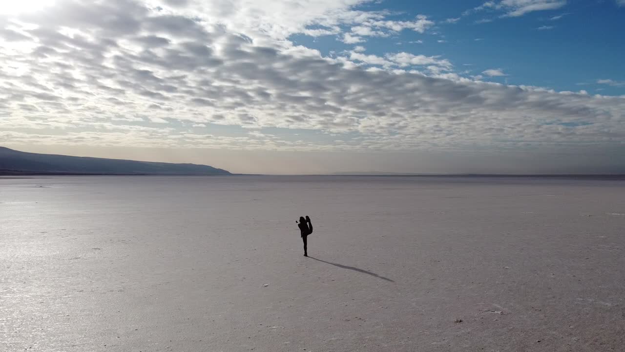 mujer joven practicando yoga en medio de un salar