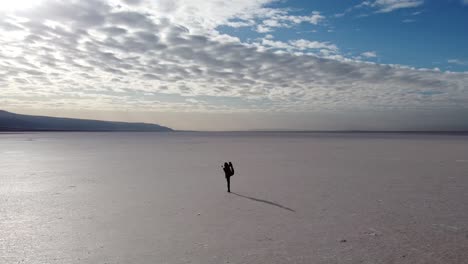 young woman practicing yoga in the middle of a salt flat