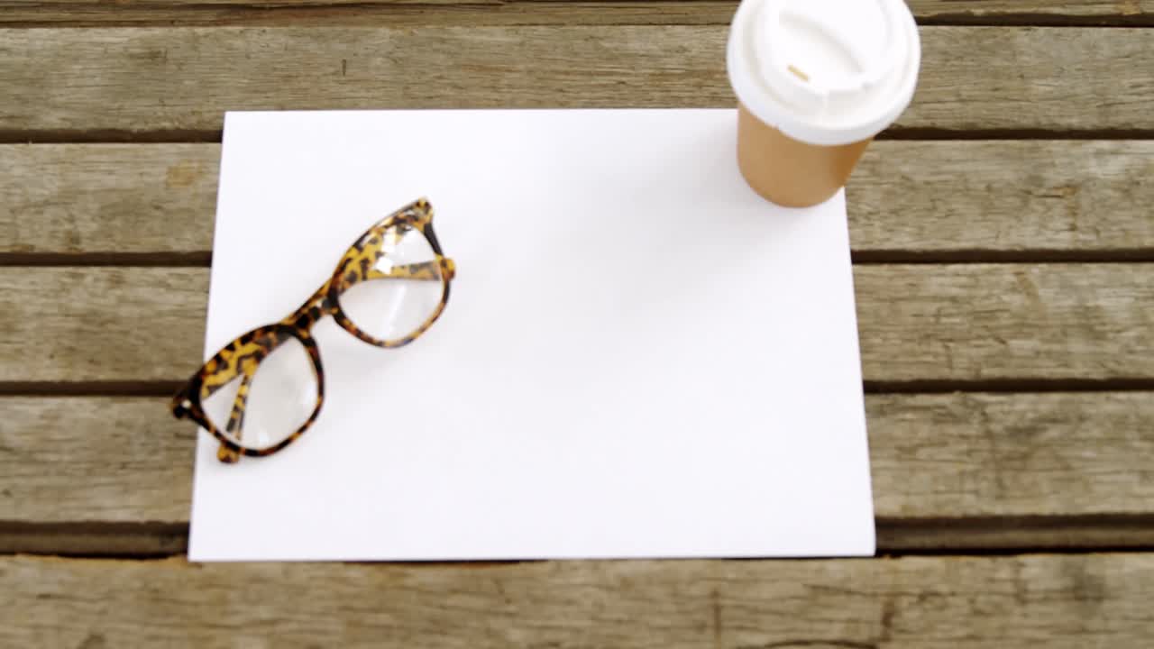 Blank paper with coffee and spectacles on wooden table 4k