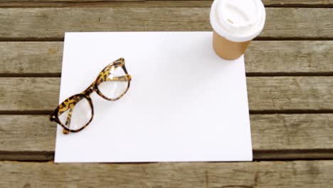 Blank-paper-with-coffee-and-spectacles-on-wooden-table-4k