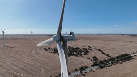 stationary drone shot of spinning wind turbine