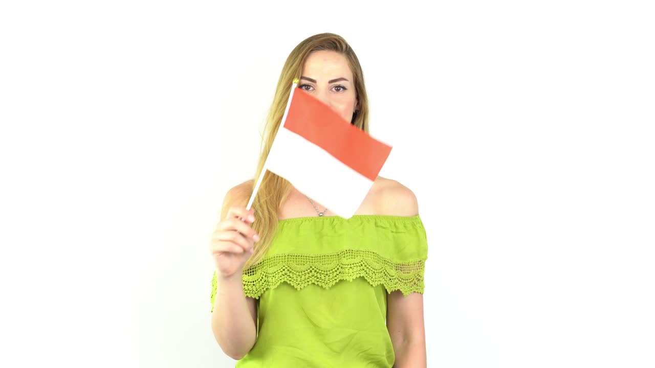 giovane donna bionda che agita la bandiera dell'indonesia davanti a uno sfondo bianco