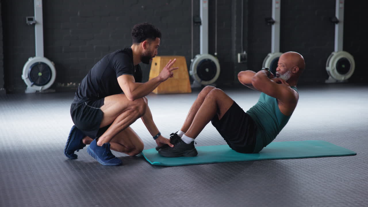 개인 트레이너가 시트업으로 노인을 돕습니다.