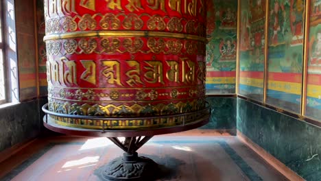 A-large-Buddhist-prayer-wheel-spinning-in-a-small-room-at-a-temple