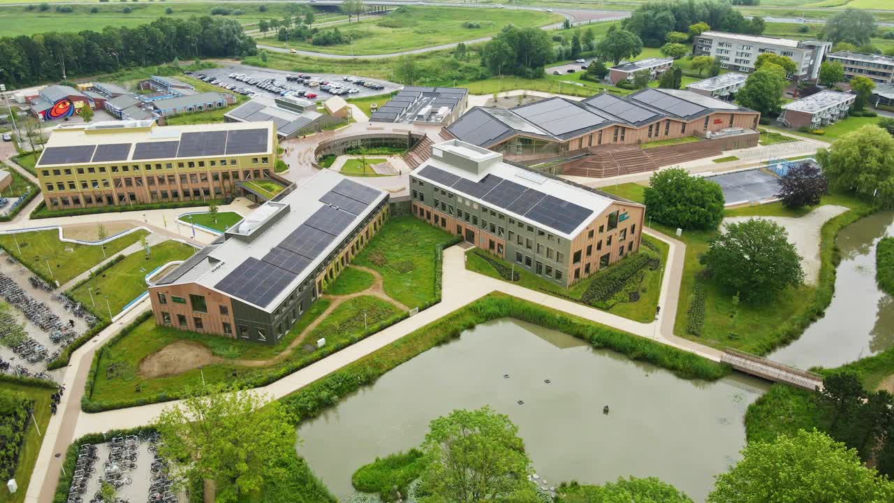 Jib up of large school campus with solar panels on the rooftops of buildings on a sunny day