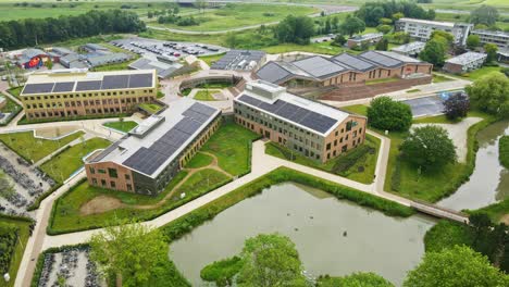 jib up of large school campus with solar panels on the rooftops of buildings on a sunny day