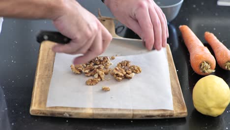 close-up chopping walnuts on a cutting board