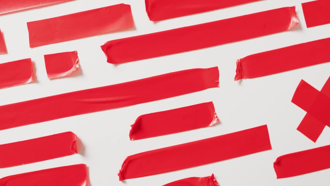 ⁇ 색 배경에 여러 개의 빨간 테이프 조각의 클로즈업 비디오