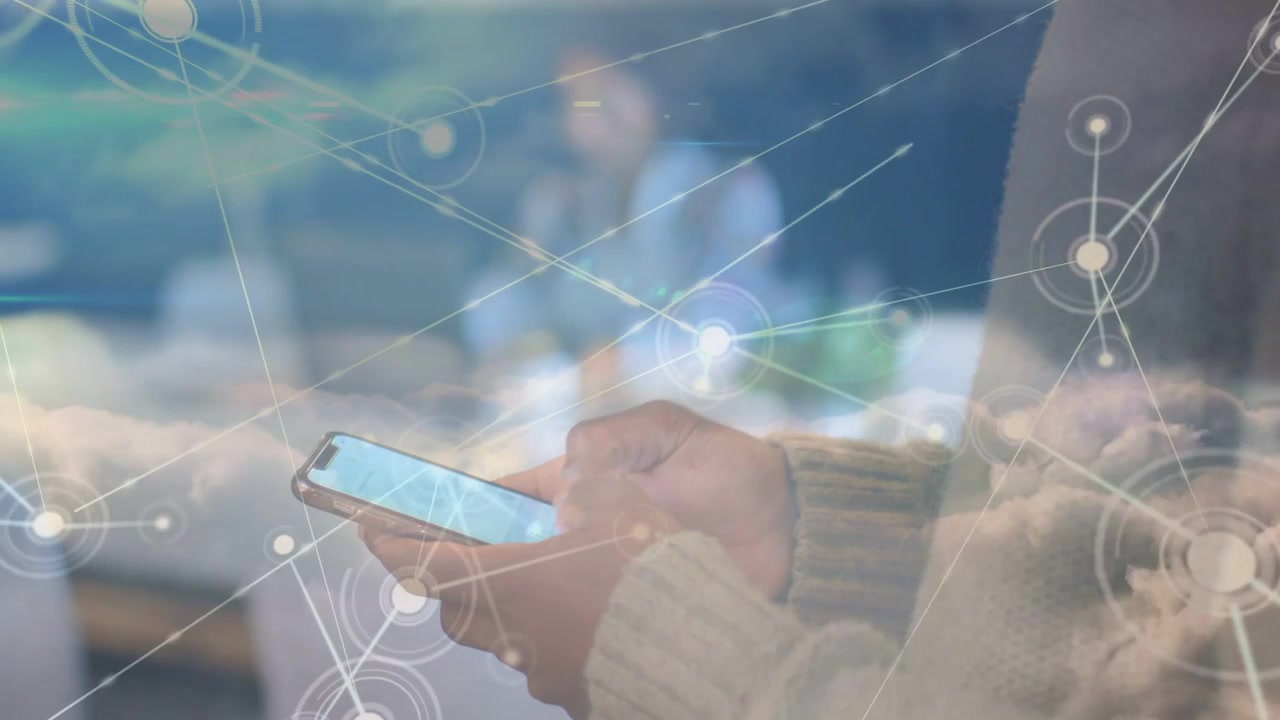 Hands holding phone tapping screen in tech hub, causing network overlay weaving hands, background