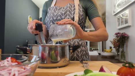 mujer cocinando sopa en la cocina