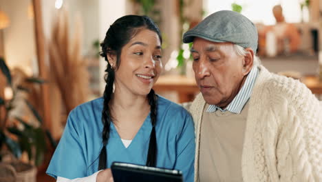 a female nurse is looking at a tablet with an elderly man.