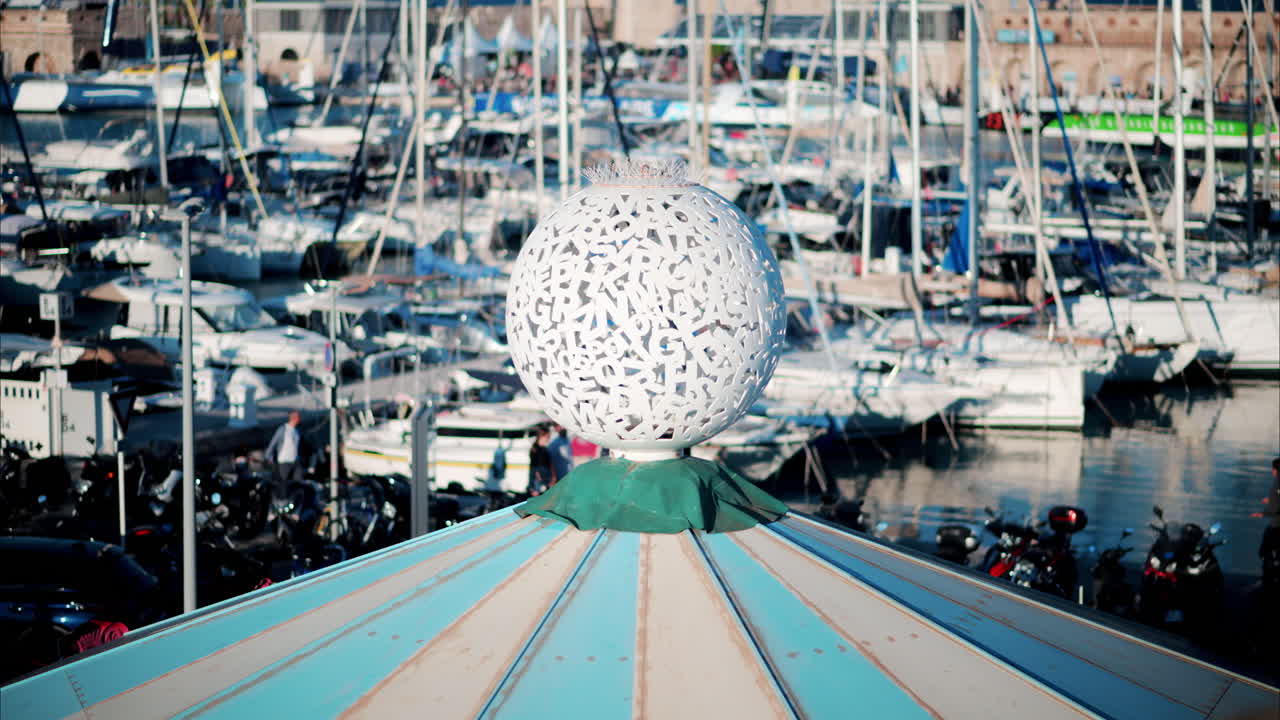 The top of a carousel spinning with the Port Vauban in Antibes, France on the background