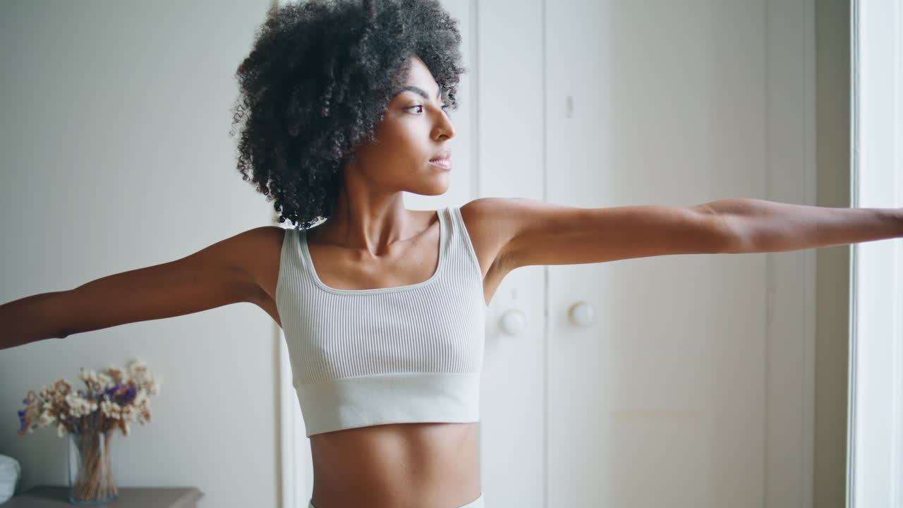 chica de yoga haciendo pendientes de cerca. mujer africana realizando asana postura de estiramiento
