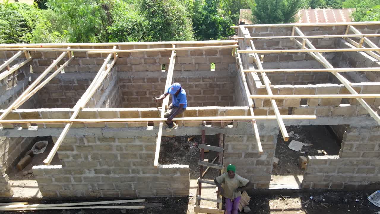 Aerial drone view of the mason working over the rooftop. Drone view of the constructor working on the roof.
