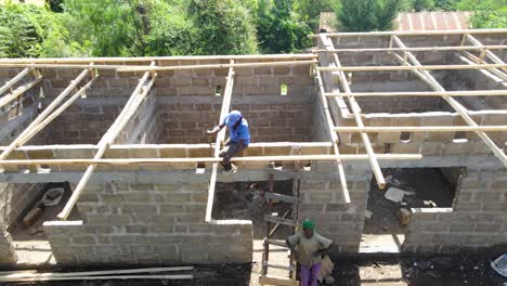 aerial drone view of the mason working over the rooftop. drone view of the constructor working on the roof.