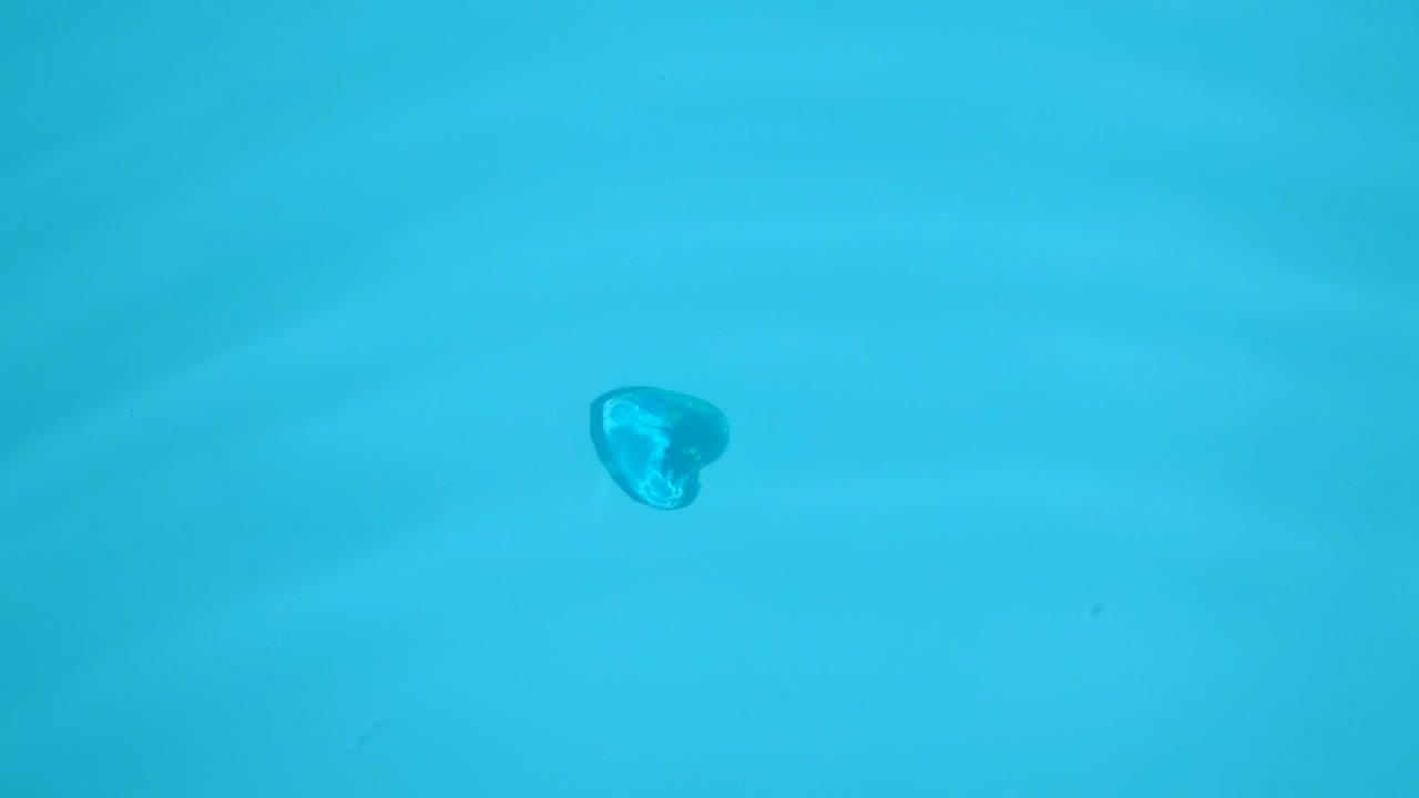 심장 모양의 보석이 파란 물로 바다 바닥에 있습니다.