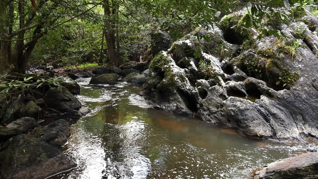 agua suave que fluye a través de un arroyo rocoso