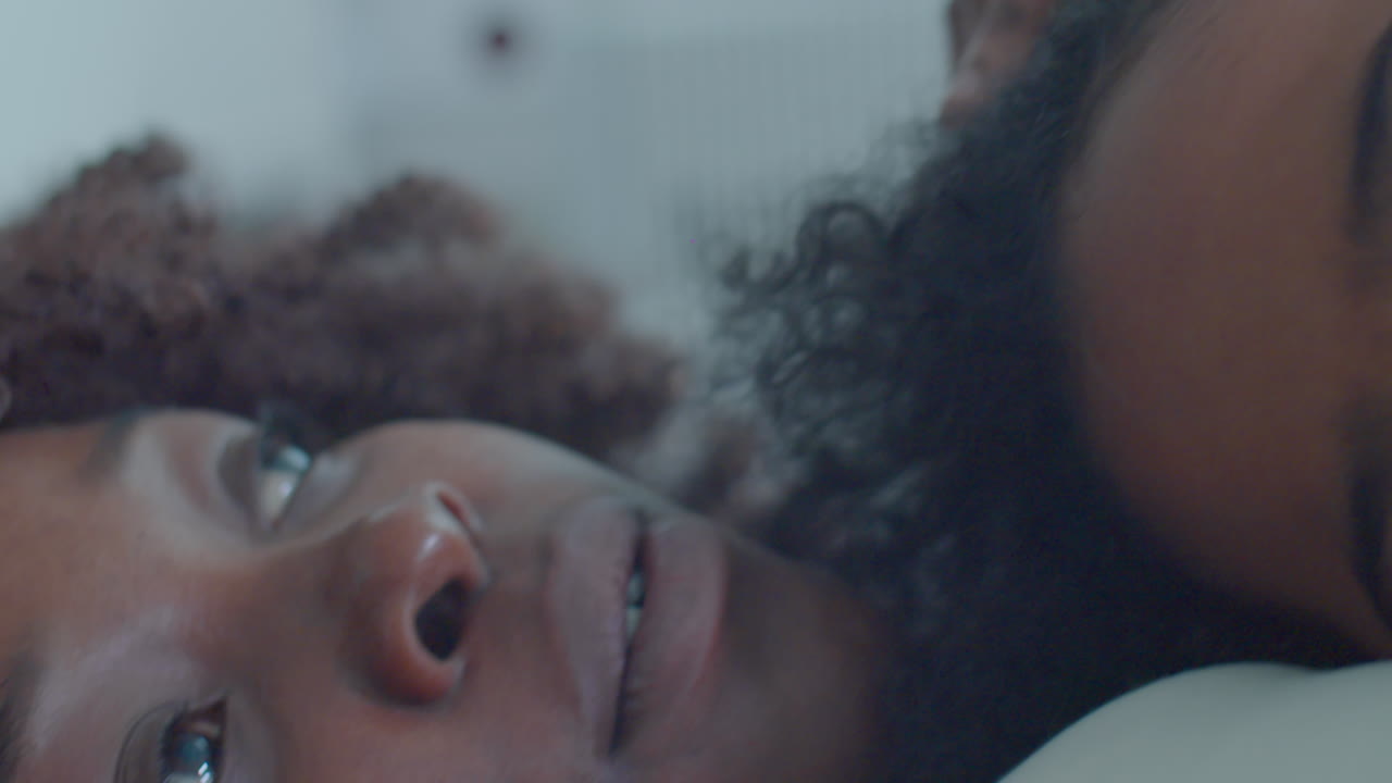 African American Woman Cuddling Sleeping Son