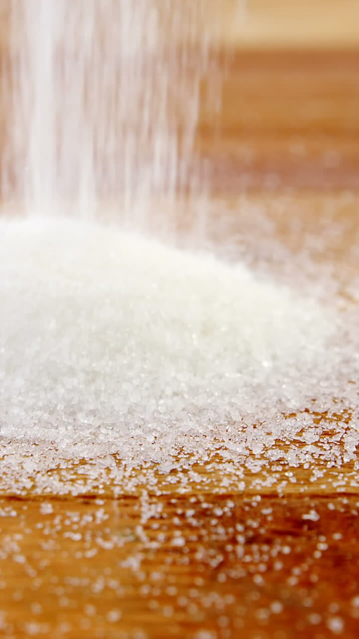 Sugar pouring on a wooden table