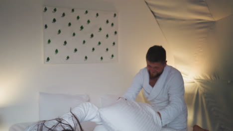 pelea de almohadas en una acogedora habitación de hotel