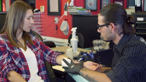 Woman-Sits-In-Chair-Having-Tattoo-In-Parlor-Shot-On-R3D