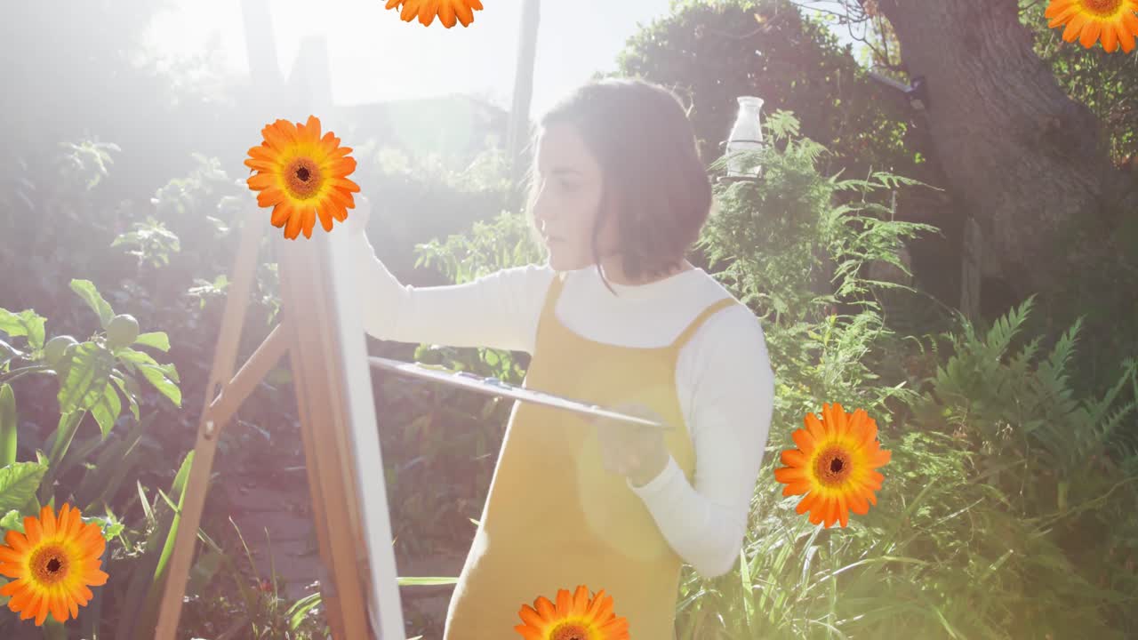 꽃 아이콘 의 복합 영상 은 정원 에 있는 백인 여성 예술가 의 그림 에 반해 떨어지고 있다