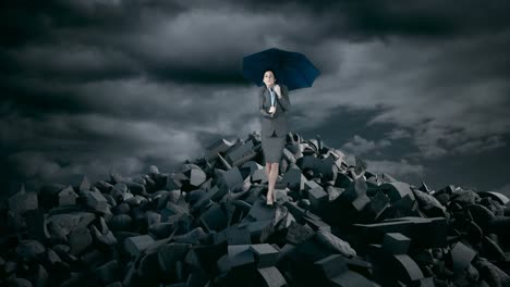 Businesswoman-with-umbrella-standing-on-debris-rocks-during-storm
