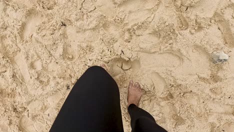 persona caminando por una playa de arena